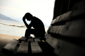 Young man sitting looking upset